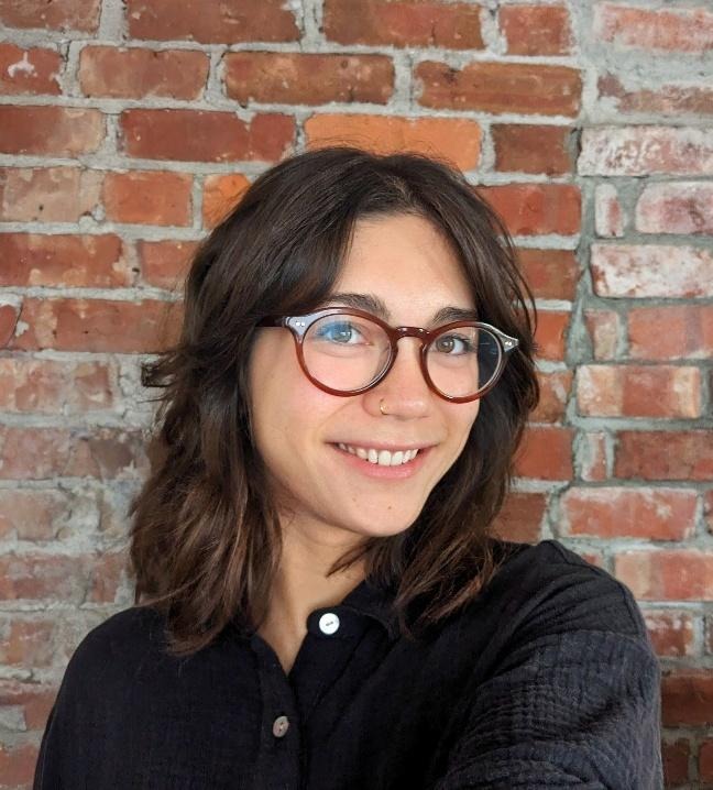 A person wearing glasses and smiling

AI-generated content may be incorrect.